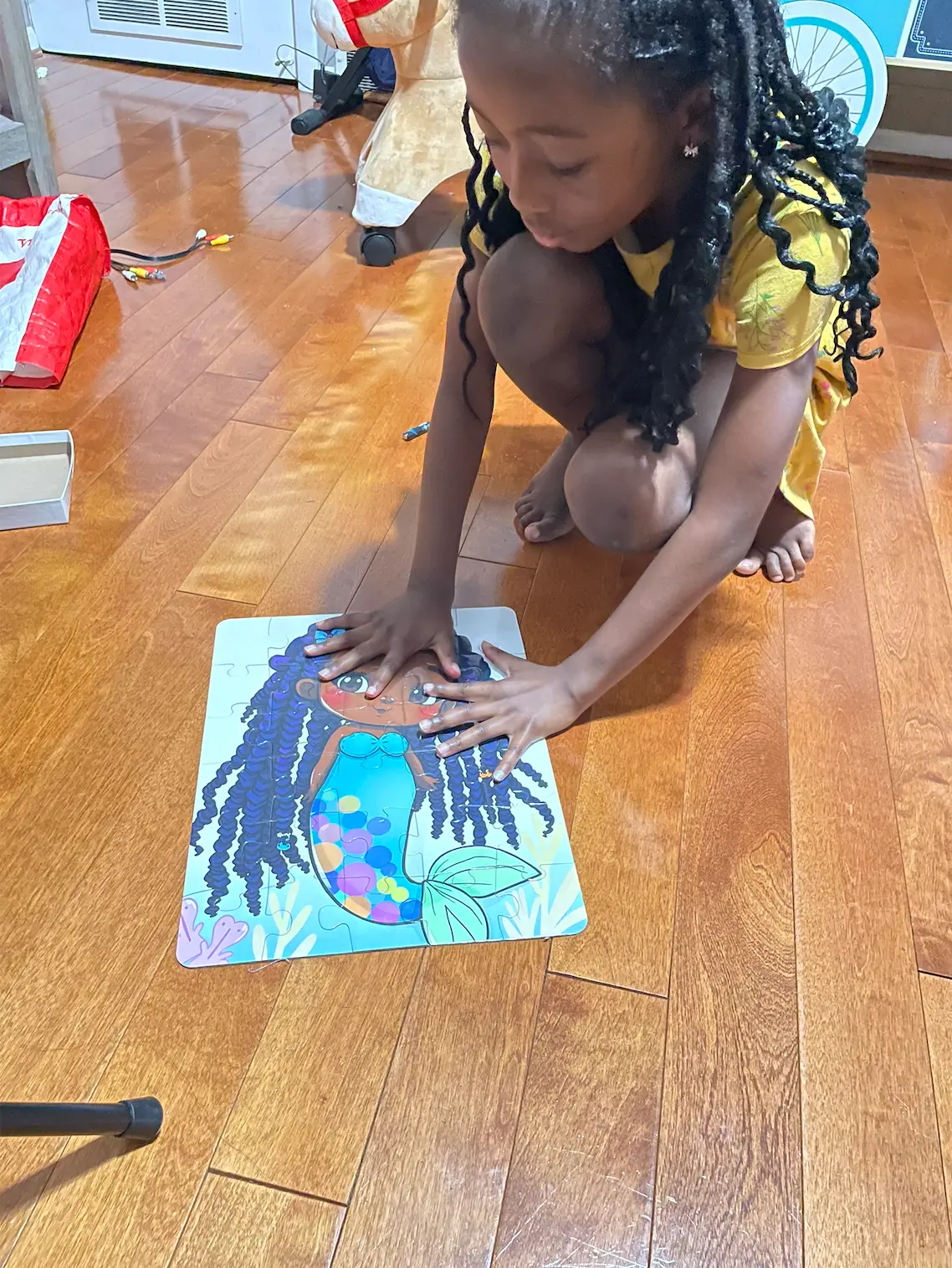 Augustine pressing down the finished original mermaid puzzle